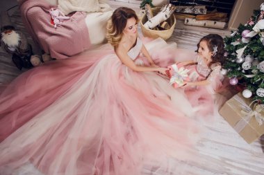 Bayram, kutlama ve insanlar kavramı - Noel iç arka plan üzerinde şık elbiseli Genç kadın. Tahıl anne ve kızı ile görüntü