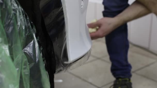 Primer plano de las manos del hombre que despegan la película con la capucha blanca coche caro. Esta película protege el vehículo de la pintura en bruto . — Vídeos de Stock