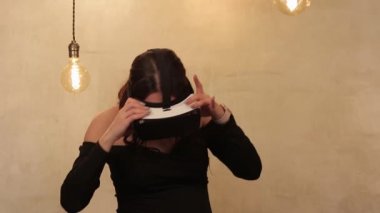 Modern kadınlar ilgi ile paralel gerçeklik ve seyretmek video ya da film gözlük kullanmak, eğlenmek ve geceleri parlak yatak odasında otururken patlamış mısır yemek. Genç kadın ile Orta Avrupa görünüm