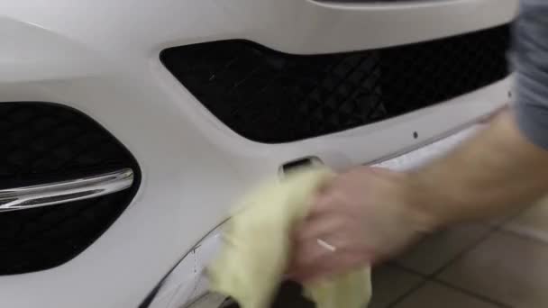 Close up shot of the hands of man who unstick the film with white cowl expensive car. This film protects the vehicle from the rough painting. — Stock Video