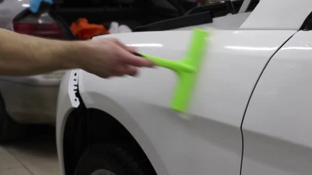 Nära upp skott av händerna på mannen som loss filmen med vit kåpa dyr bil. Denna film skyddar fordonet från grov målningen. — Stockvideo