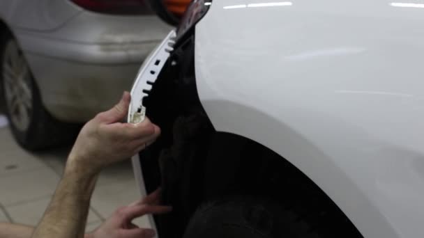 Close-up shot van de handen van man die Registreer de film met witte cowl dure auto. Deze film beschermt het voertuig tegen het ruwe schilderij. — Stockvideo