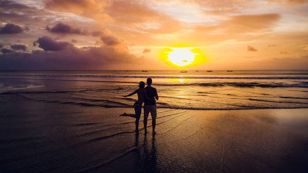 Schöne Mädchen auf Sonnenuntergang Hintergrund am Sandstrand — Stockfoto