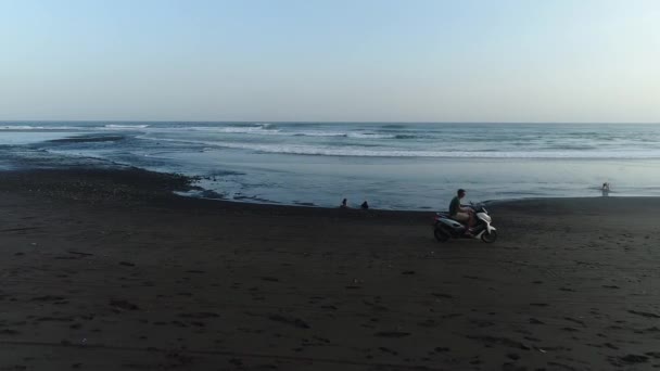 Homem monta scooter na praia — Vídeo de Stock