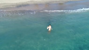 Kız dalga ile kapsar. Hava üstten görünüm genç kadın Bali mavi deniz yüzme