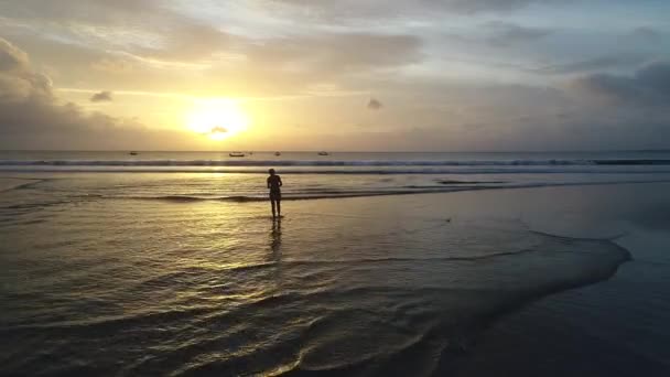 Yalnız'nde günbatımı kumsalda yürüyen genç kadın — Stok video