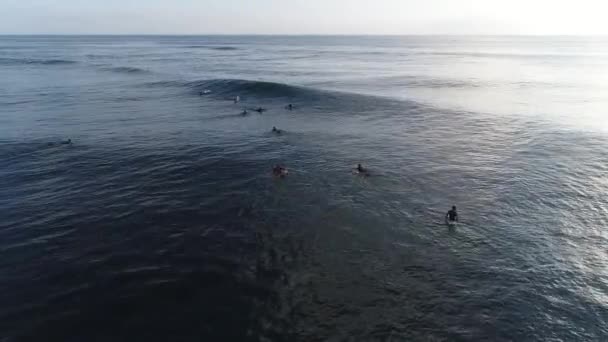 Surfer jazdy na falach w zachód słońca, góry z widokiem na ocean — Wideo stockowe