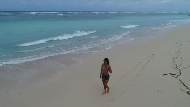 Mujer joven caminando sola en la playa al atardecer — Vídeos de Stock