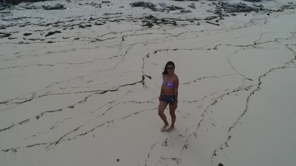 Jonge vrouw lopen alleen op strand in de zonsondergang — Stockvideo