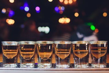 Ahşap bir masa üzerinde alkollü bir içki ile gözlük.