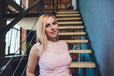 Raslantı giyimli çekici hamile kadın ayakta ev, kamera seyir ve iken gülümseyen