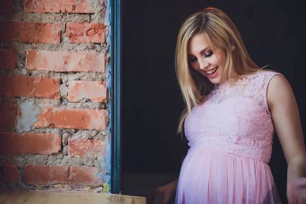 Casually habillé jolie femme enceinte debout à la maison, regardant caméra et souriant tout en — Photo