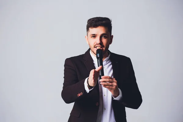 Showman interviewer with emotions. Young elegant man holding microphone against white background.Showman concept. — Stock Photo, Image