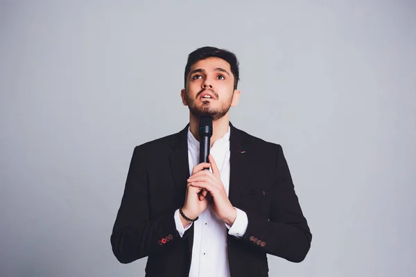 Showman interviewer with emotions. Young elegant man holding microphone against white background.Showman concept. — Stock Photo, Image