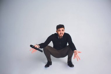 Şovmen görüşmeci duygularla. Beyaz arka plan üzerinde mikrofon tutan zarif delikanlı. Şovmen kavramı.