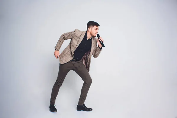 Showman interviewer with emotions. Young elegant man holding microphone against white background.Showman concept. — Stock Photo, Image