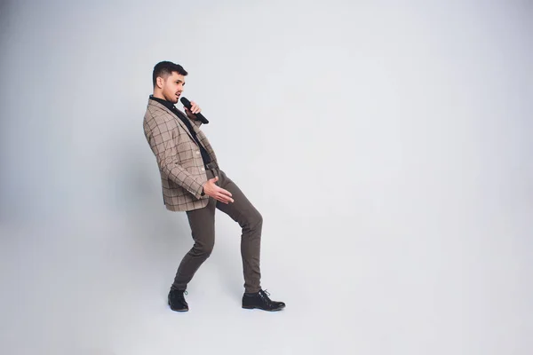 Showman interviewer with emotions. Young elegant man holding microphone against white background.Showman concept. — Stock Photo, Image