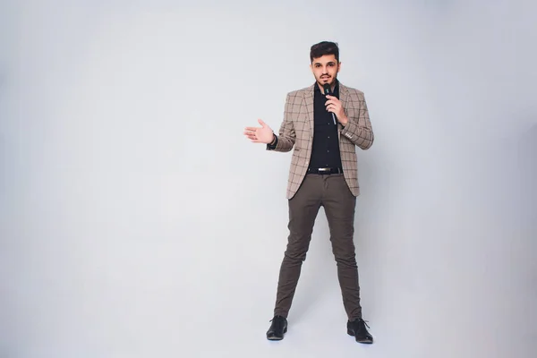 Entrevistador de Showman con emociones. Joven hombre elegante sosteniendo el micrófono contra fondo blanco.Concepto de Showman . —  Fotos de Stock