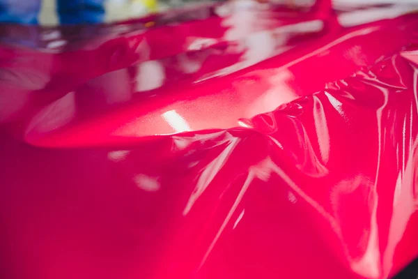 Αυτοκίνητο ειδικός αναδίπλωσης βάζοντας βινυλίου αλουμινόχαρτο ή μεμβράνη στο αυτοκίνητο περιτυλίγματος προστατευτικό φιλμ γιοτ, πλοίο, αυτοκίνητο, σκάφος, κινητό σπίτι. ροζ ταινία κόκκινο χέρι τραβά — Φωτογραφία Αρχείου