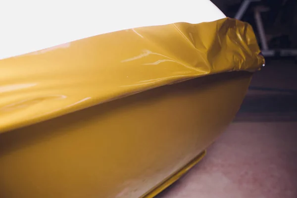 Αυτοκίνητο ειδικός αναδίπλωσης βάζοντας βινυλίου αλουμινόχαρτο ή μεμβράνη στο αυτοκίνητο περιτυλίγματος προστατευτικό φιλμ γιοτ, πλοίο, αυτοκίνητο, σκάφος, κινητό σπίτι. Κίτρινο χρυσό ταινία χέρι τραβά — Φωτογραφία Αρχείου