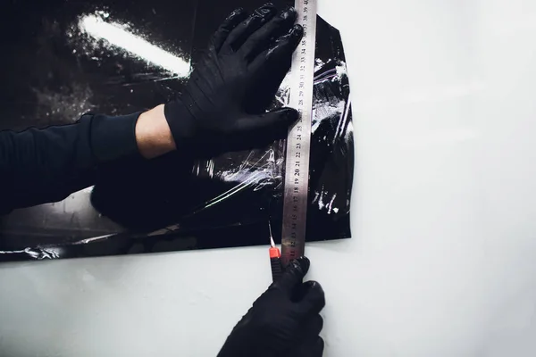 Применение тонирующей фольги на окне автомобиля в гараже — стоковое фото