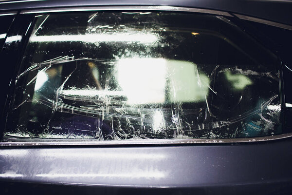 Применение тонирующей фольги на окне автомобиля в гараже
