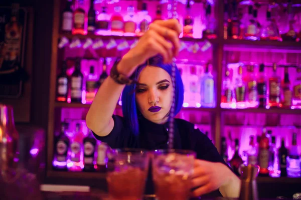 Барменша. девушка с голубыми волосами. приготовление коктейлей в ночном баре — стоковое фото
