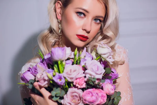 Jolie jeune fille. Femme blonde avec de longs cheveux bouclés luxueux. Le matin des mariées. Prendre le bouquet de mariage dans les mains — Photo