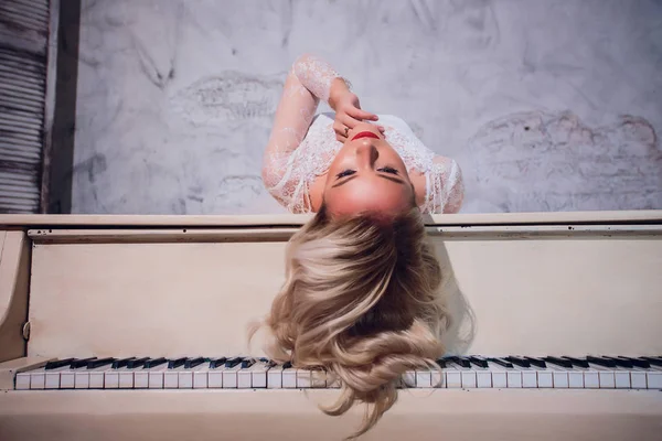 Skönhet blond kvinna porträtt. Vackra brud med långt lockigt blont hår sitter vid pianot. Vitt hår. Perfekt hud och Make up. Löshår. — Stockfoto
