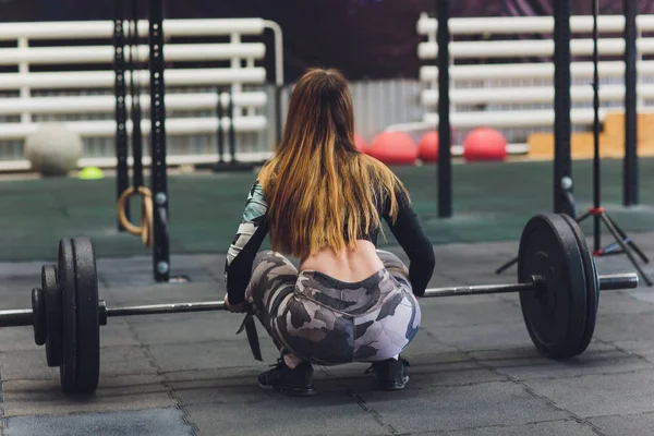 Atractiva joven deportista con barra. Levantamiento mortal. vista trasera, culo atlético de las mujeres —  Fotos de Stock