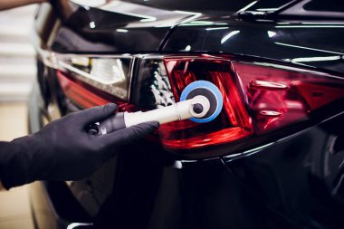 Araba Perdah holding balmumu işçisi eller Lehçe ve Lehçe araba ayrıntılı veya valeting kavramı stop lambası kırmızı araba