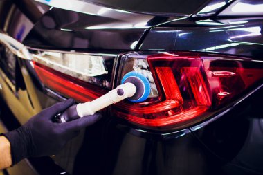 Araba Perdah holding balmumu işçisi eller Lehçe ve Lehçe araba ayrıntılı veya valeting kavramı stop lambası kırmızı araba