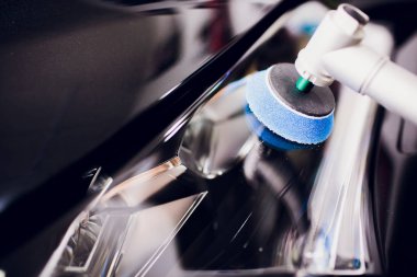 Araba Perdah holding balmumu işçisi eller Lehçe ve Lehçe araba ayrıntılı veya valeting kavramı açık beyaz otomatik far