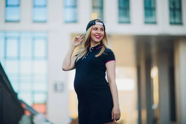 Młoda kobieta w ciąży na tle budynku mieszkalnego — Zdjęcie stockowe