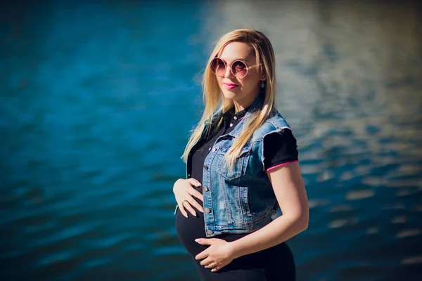 Młoda kobieta w ciąży na tle budynku mieszkalnego — Zdjęcie stockowe