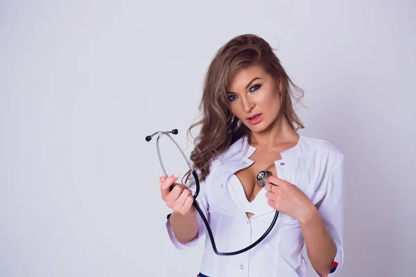 Молодая женщина-врач улыбается лицом со стетоскопом и белым халатом — стоковое фото