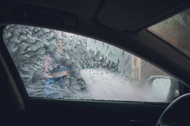 Çekici kadın self servis, yıkama otomobil el ile araba yıkama köpük ile temizlik su baskı. Self servis istasyonu her bakıldığında yüksek basınç blaster pencere yıkama arabaya arabanın içinden