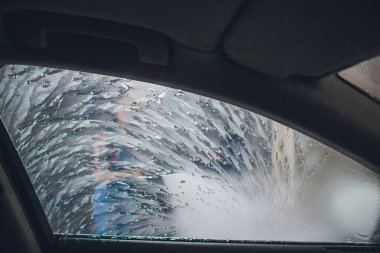 Çekici kadın self servis, yıkama otomobil el ile araba yıkama köpük ile temizlik su baskı. Self servis istasyonu her bakıldığında yüksek basınç blaster pencere yıkama arabaya arabanın içinden