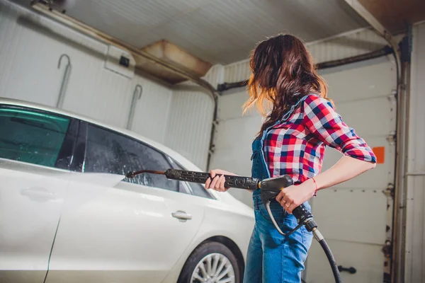 Attraktiv kvinna Tvätta bil manuell bil tvätt självbetjäning, rengöring med skum, pressade vatten. Transport vård koncept. Tvätta bilen i self service station med högtryck blaster — Stockfoto