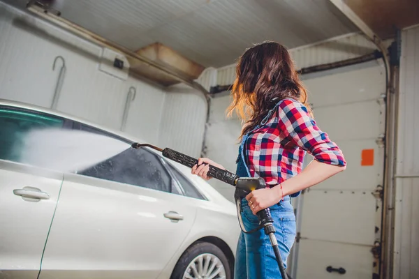 Atraktivní žena mytí automobilů ruční mytí samoobsluhy, čištění pěnou, pod tlakem vody. Doprava koncept péče. Mytí aut v vlastní čerpací stanici s vysokým tlakem blaster — Stock fotografie