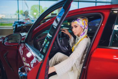 Özellik ve insanlar kavramı - Müslüman kadın türban ile araba anahtar şu arabayı arka plan göster. mutlu kadın satıcısı Otomobil Fuarı veya salon arabanın anahtarını alarak