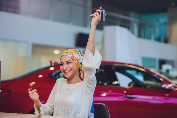 Mulher bonita desfrutando momento feliz recebendo chave do carro do vendedor de automóveis salão de beleza. mulher muçulmana no hijab — Fotografia de Stock