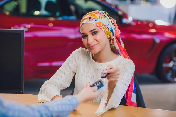 Hermosa mujer disfrutando del momento feliz de conseguir la llave del coche del vendedor de automóviles salón. mujer musulmana en hijab — Foto de Stock