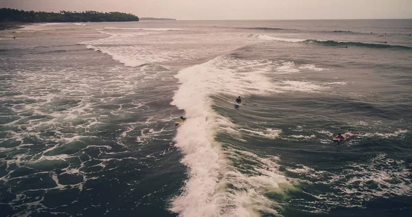 Vue aérienne surfeurs et vagues dans l'océan tropical. Vue du dessus — Photo