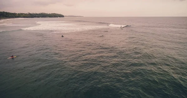 Vue aérienne surfeurs et vagues dans l'océan tropical. Vue du dessus — Photo