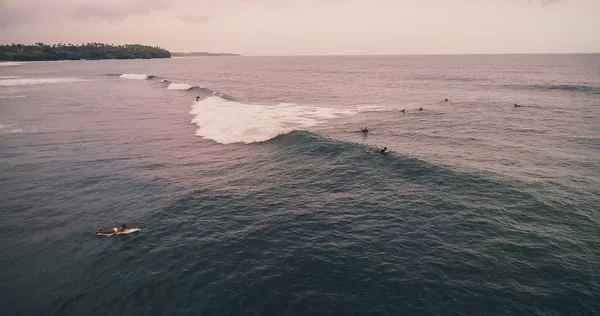 Vue aérienne surfeurs et vagues dans l'océan tropical. Vue du dessus — Photo