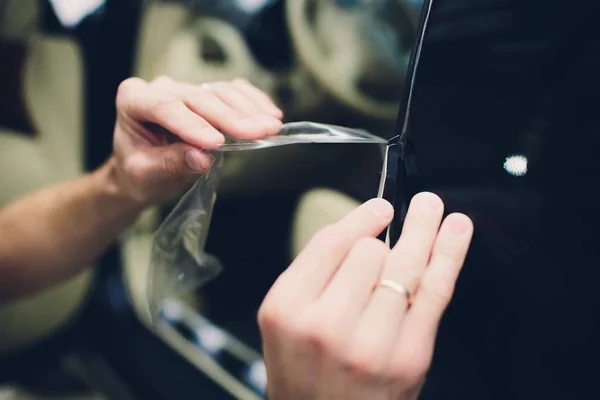 Trabalhador mãos instala filme de proteção de pintura de carro — Fotografia de Stock