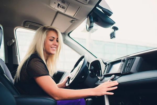 Feliz sorriso feminino regozijando-se em nova compra cara no auto showroom. Cliente bonito sentado na porta do carro superior dobrável branco . — Fotografia de Stock