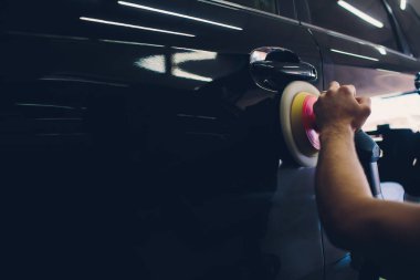 Araba temizleme - oto tamir atölyesinde orbital cilalayıcı ile eller