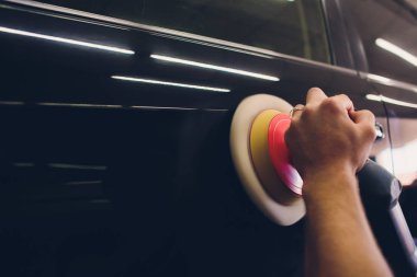 Araba temizleme - oto tamir atölyesinde orbital cilalayıcı ile eller